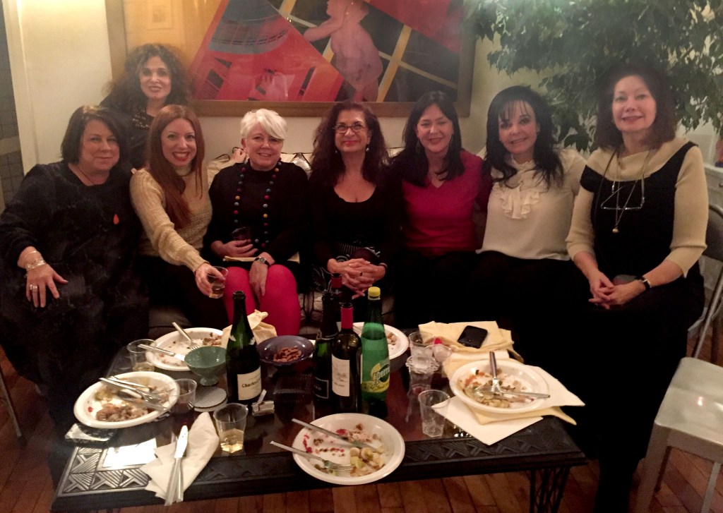Author Lisa Anselmo posing for a photo on a sofa with friends.
